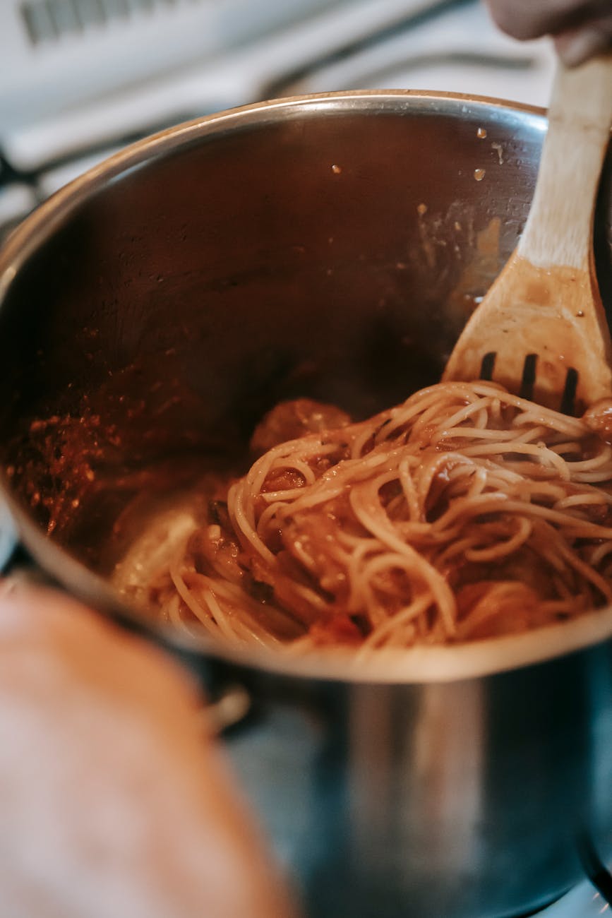 yummy pasta with tomato sauce in metal saucepan