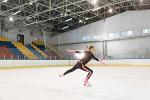 girl in pink and black long sleeve bodysuit doing ice skating