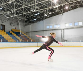 girl in pink and black long sleeve bodysuit doing ice skating