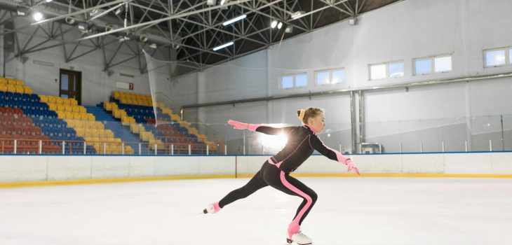 girl in pink and black long sleeve bodysuit doing ice skating