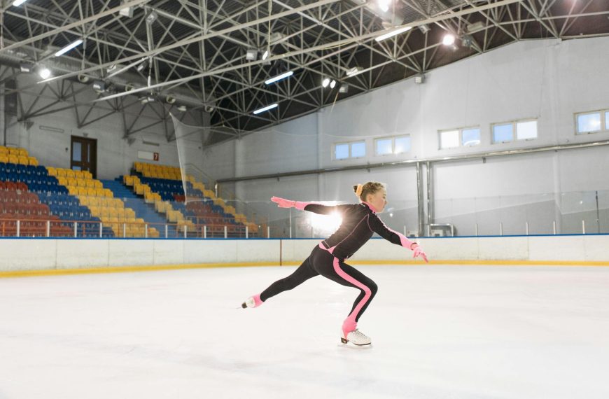 girl in pink and black long sleeve bodysuit doing ice skating