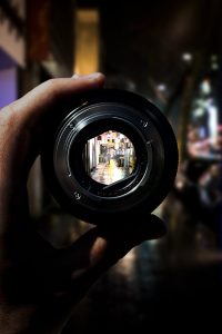person holding black camera lens