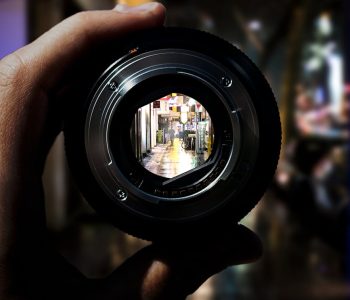 person holding black camera lens