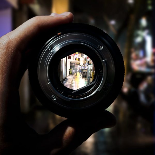 person holding black camera lens